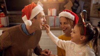 Little girl feeds her father while having Christmas lunch at dining table scaled e1671503241399 Don't Diet This Christmas: A PT's advice